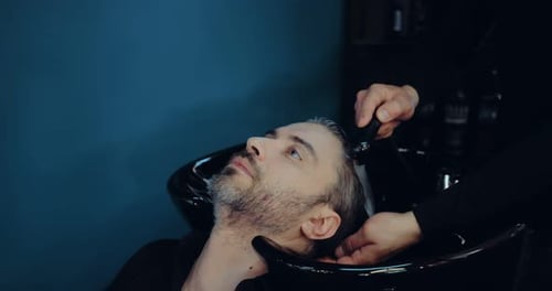 Man Having Hair Washed at Salon Wash Basin