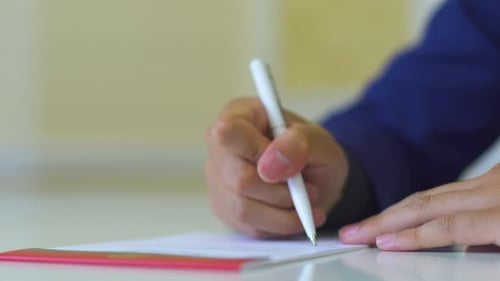 Unterzeichnung eines Vertrags mit einem Anwalt. Ein Mann bringt seine Unterschrift zu Papier.