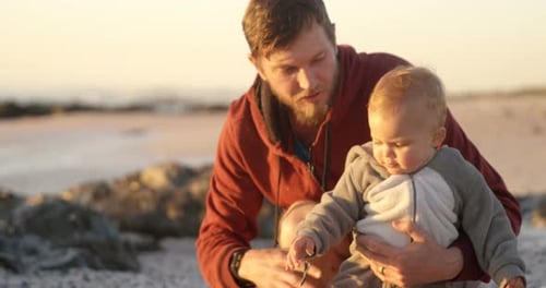 Loving Father with Baby on Beach at Sunset