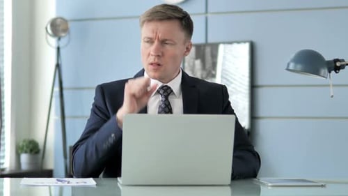 Man in Suit Coughing While Using Laptop