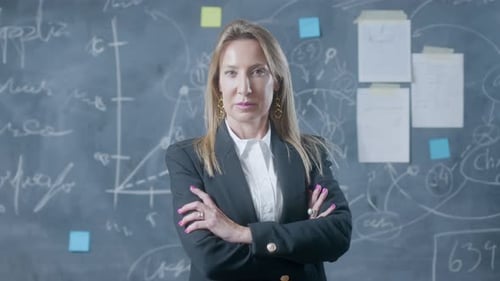 Confident Woman Stands in Front of Chalkboard