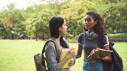Two Multi Ethnic University Student Friends Discussing and Talking in the Park