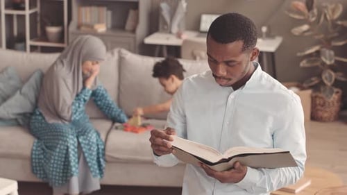 African American Muslim Man Reading Quran at Home