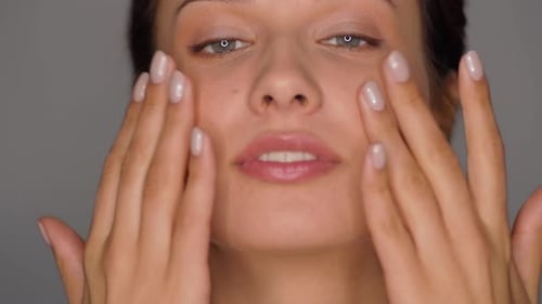 Woman Applying Moisturizer to Face and Neck