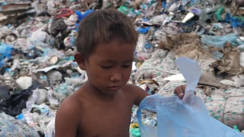 Poverty Asian Boy Collecting Trash for Sell on Garbage Dump
