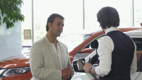 Handsome Mature Man Choosing a New Automobile at the Dealership
