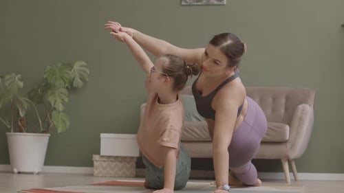 Girl Doing Yoga with Brown-Haired Woman at Home