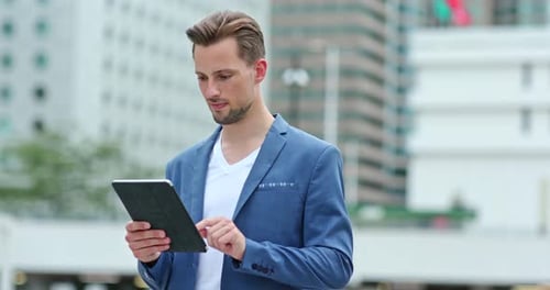 Man Using Tablet in City