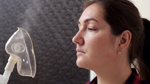 Jeune femme avec masque d'inhalation