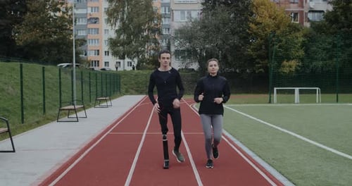 Athletes Running on Track with Prosthetic Leg
