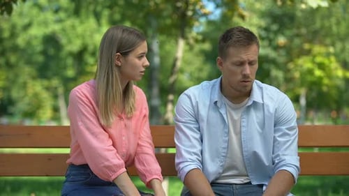 Young Couple Having Difficult Conversation on Park Bench
