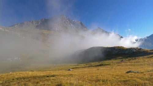 Alpine landscape morning fog mist and clouds, mountain ridges and peaks of the Alps