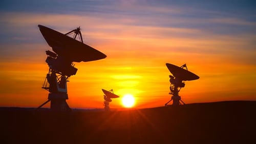 Radio Telescope Array Silhouetted Against a Golden Sunset Sky