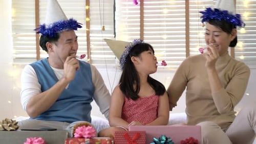 Family Celebrates Birthday at Home with Party Hats