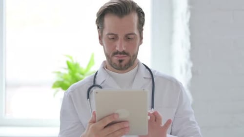 Portrait of Young Doctor Using Tablet in Office