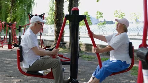 Active Senior Couple Exercising on Arm Bike Machine