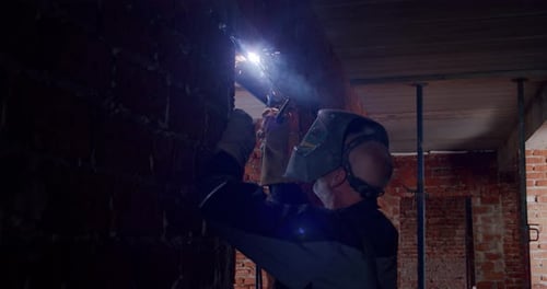 Slow Motion. Worker in a Mask, Welder Welding The Worker Performs Metal Welding at the Factory or