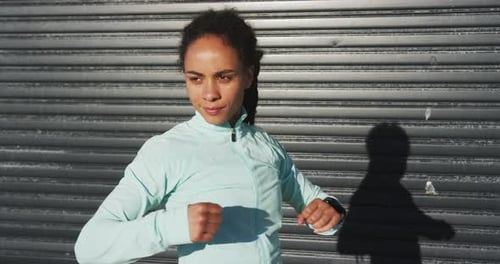 African american woman in sportswear stretching in street before exercising