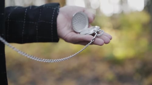 Ansicht eines Anhängers mit Armbanduhren in männlicher Hand auf verschwommenem Hintergrund