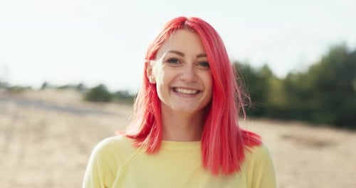 Smiling Woman with Red Hair Poses Outdoors