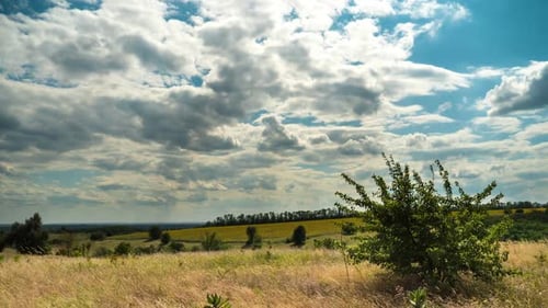 Landschaft Dramatisch Felder und sich bewegende Gewitterwolken am blauen Himmel. Zeitraffer. Wunderbares ländliches Tal