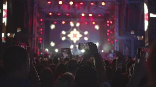 Crowd Enjoys Concert with Bright Lights at Night