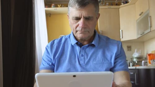 Man Using Tablet Indoors at Home