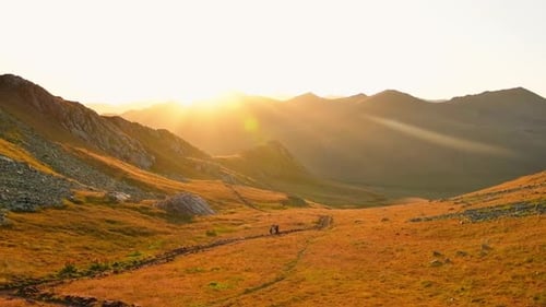 People Hiking on Mountain Trail at Sunrise