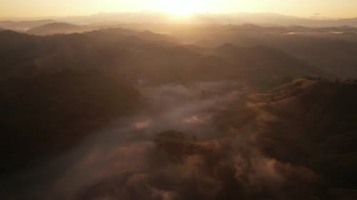 Aerial view of sunrise with fog above mountains