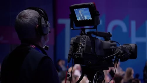 Cameraman Filming Large Tech Conference with Professional Camera