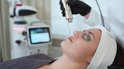 Woman in Beauty Clinic Aesthetician is Using Laser for Rejuvenation Face Skin