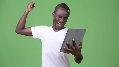 Excited Man Using Tablet Celebrates Success