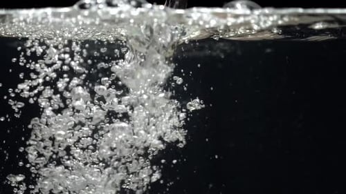Câmera lenta de água cai no aquário em um fundo preto