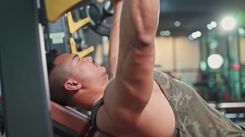 Asian Active fitness trainer man workout exercising lifting weight machine at gym stadium club.