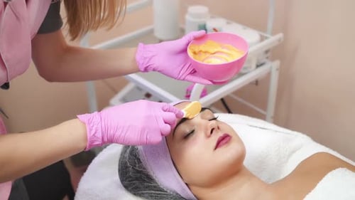 Beautician Applying Facial Mask to Woman