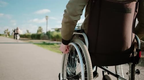 Wheelchair User Rolling on Path Outdoors