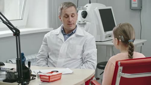 Doctor Discusses Treatment With Young Patient in Office