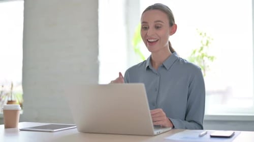 Woman Talking on Video Call on Laptop in Office