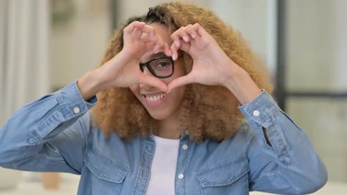 Smiling Woman Makes Heart with Hands