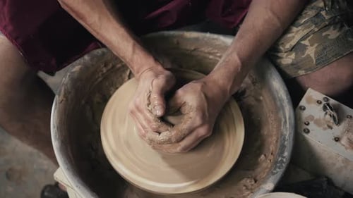Les mains d'un potier Création d'un pot en terre sur le cercle Gros plan Mains sur cercle avec de l'argile