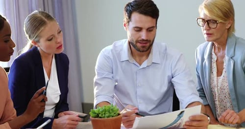 Business Team Discussing Documents in Bright Office