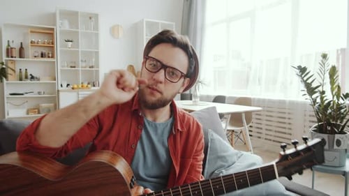 Man Playing Guitar and Singing in Living Room
