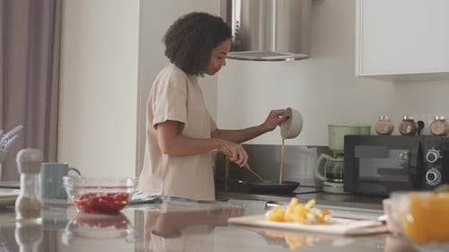 Woman Cooking Food at Home in Frying Pan