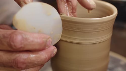 Les mains de potier fabriquent une cruche en argile à l'aide du tour de potier