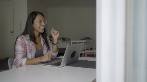 Glückliche junge Frau mit Videoanruf über Laptop.