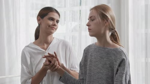 Young caucasian woman depressed while friends encourage in the bedroom at home.