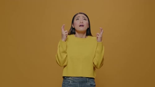 Woman Crosses Fingers Hoping for Good Luck