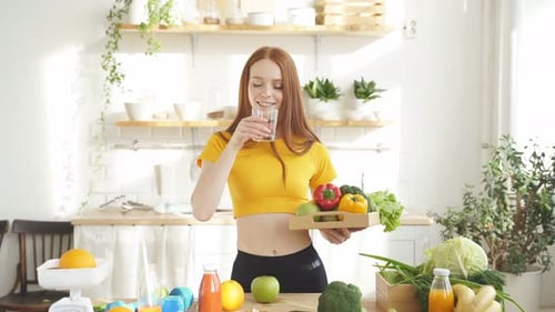 Woman Stands at a Table with a Lot of Vegan Food Ingredients She Talks About Proper Nutrition at