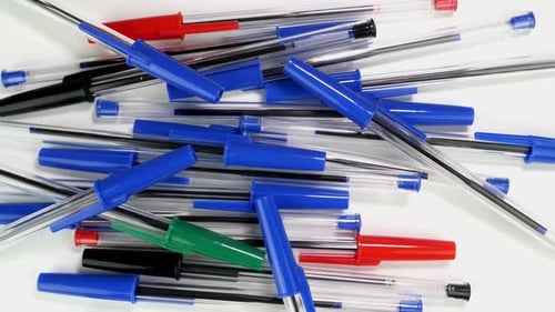 A Lot of Colorful Ballpoint Pens Spinning Rotate Slowly on White Screen in Office or School