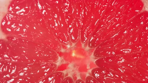Drop of Water Flows Down the Surface of a Ripe Juicy Grapefruit Slice